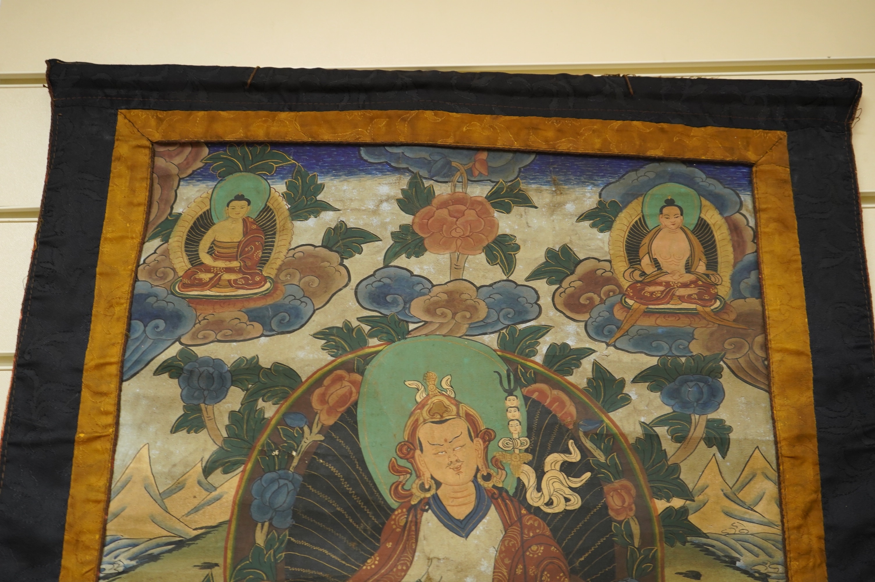 A Tibetan painted silk thangka, depicting Padmadambhara seated on a throne of lotus petals, 19th century